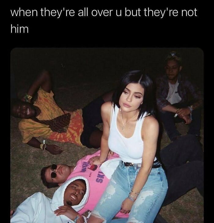 Group of young people sitting and lying on grass, capturing a relatable moment about relationships and feelings.