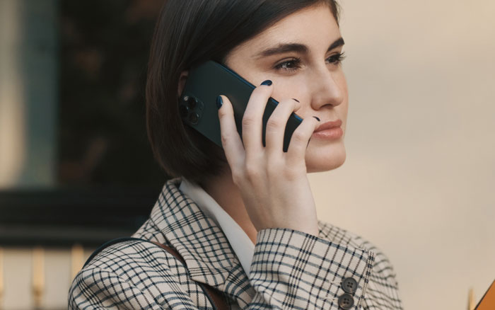 Woman in plaid blazer talking on phone, reflecting emotions tied to a man proposing two months after breakup.