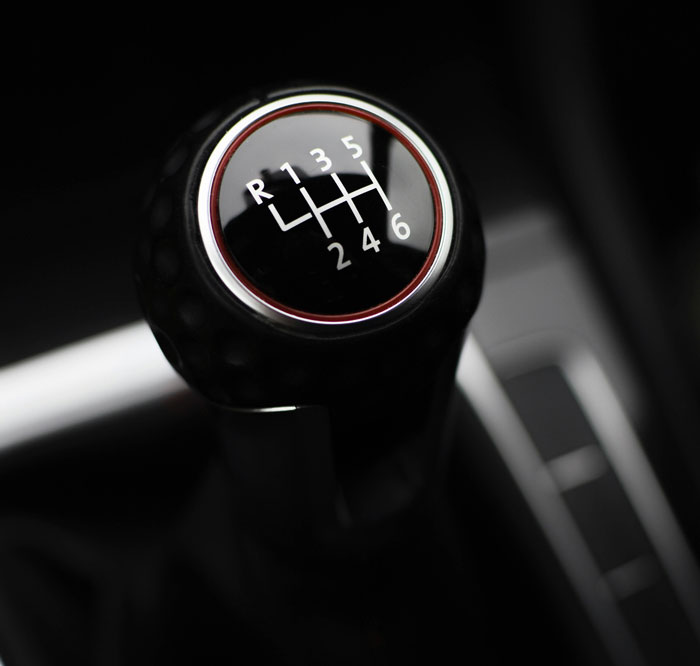 Close-up of a manual car gear shift k**b symbolizing challenges bosses face with worst employees at work.