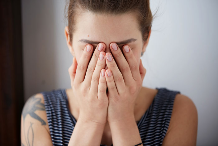 Woman covering her face, appearing distressed and rethinking her marriage after disturbing husband&rsquo;s confession.