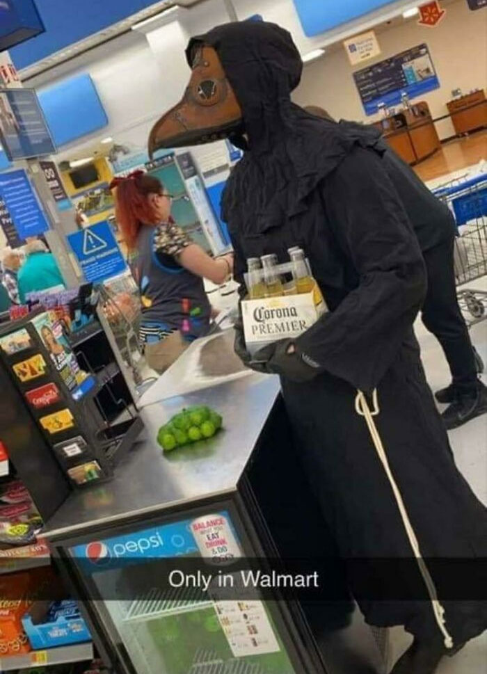 Person wearing a plague doctor costume holding beer inside Walmart, showcasing one of the wildest people of Walmart moments.