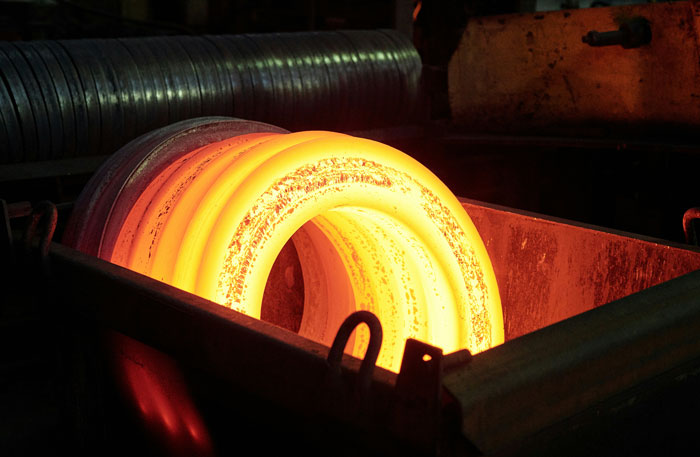 Glowing hot metal rings in an industrial foundry, representing worst places visited imagery