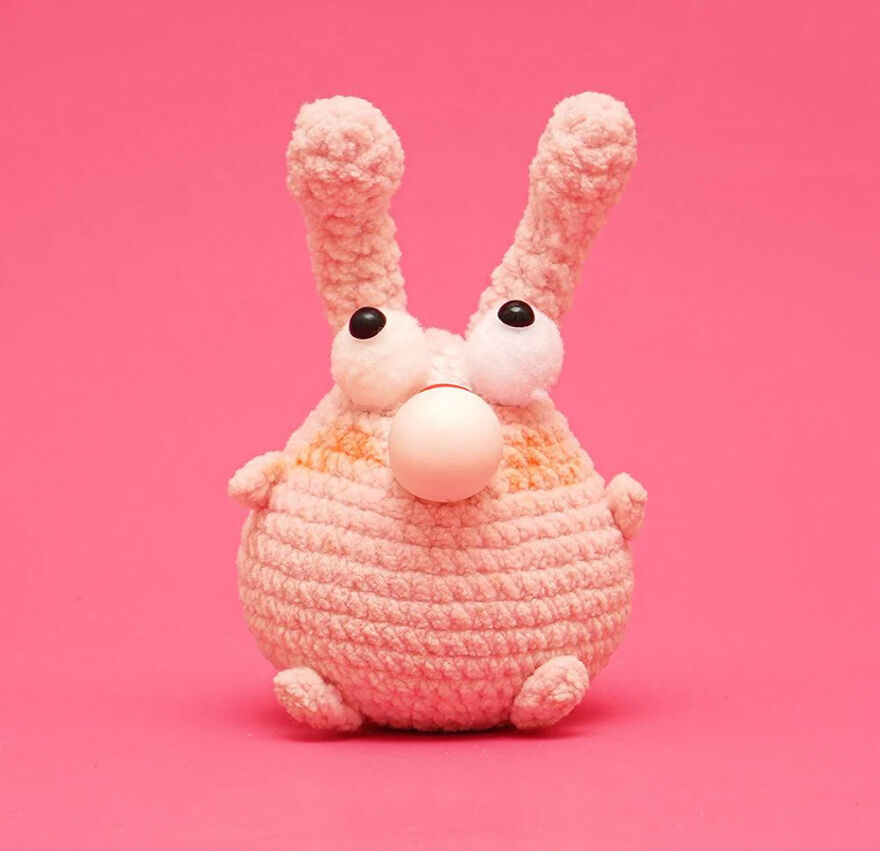 Crochet animal with big eyes and long ears, made of soft yarn in light pink, showcasing personality and charm.