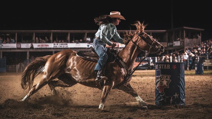 Barrel racer in action at rodeo arena, featured among award-winning photos from the 2025 Photographer of the Year contest.