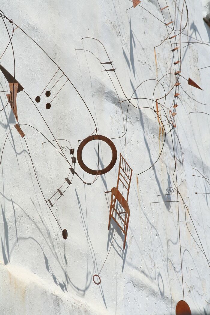 Abstract metal wire wall art with geometric shapes casting shadows, featured in award-winning photos from Photographer of the Year contest.