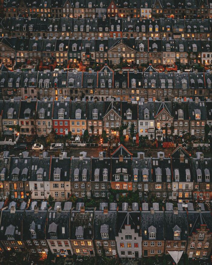 Aerial view of closely packed houses at dusk with warm lights, featured in award-winning photos from Photographer of the Year contest.