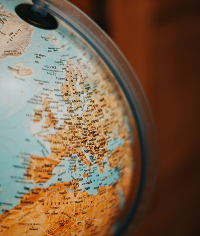 Close-up of a globe highlighting European countries, symbolizing daycare workers learning unexpected family secrets.