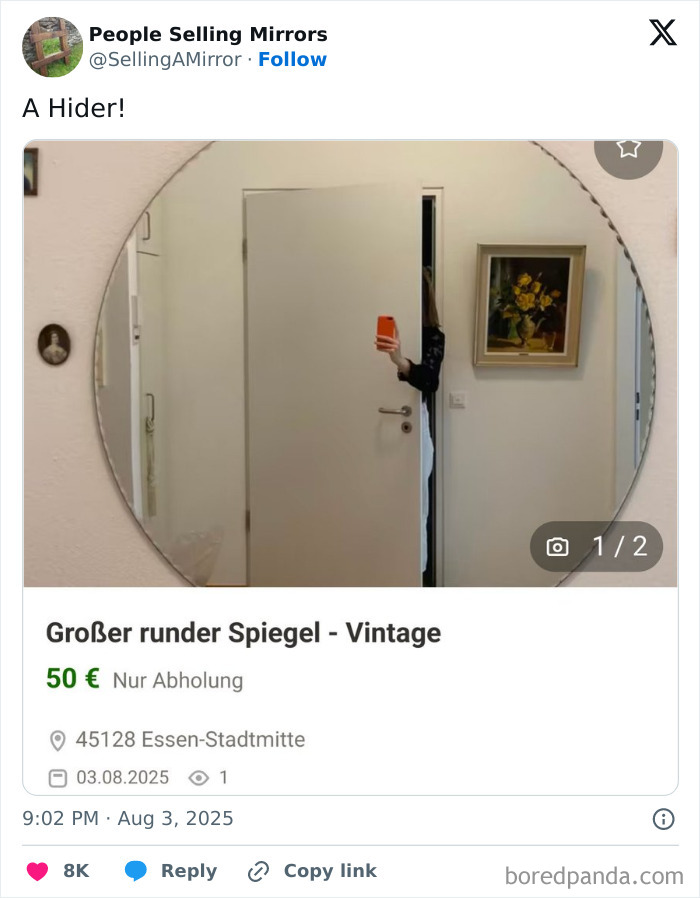 Round vintage mirror for sale with person partially hidden in the reflection holding an orange phone in a doorway.