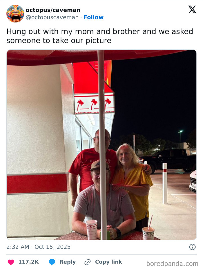 Family photo at night outside a restaurant with a pole perfectly splitting three people, funny Netflix comment section tweet.