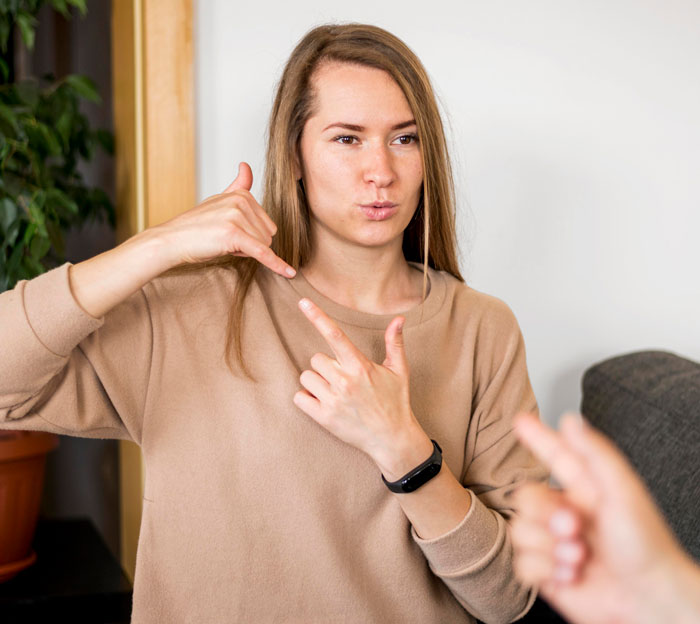 Woman using sign language at home, illustrating challenges when husband leaves because he can't deal with deaf baby.