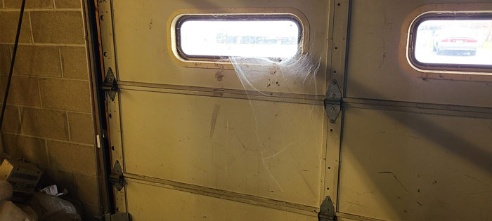 Old office door covered in grime and spider webs, part of cleaning out deceased coworker&rsquo;s workspace task.