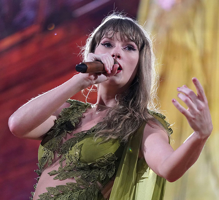 Taylor Swift performing on stage wearing green outfit, sparking backlash over leaked lyrics from The Life of a Showgirl. Taylor Swift performing on stage wearing green outfit, sparking backlash over leaked lyrics from The Life of a Showgirl.