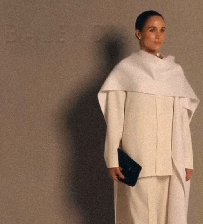 A woman in a stylish white outfit holding a black clutch, representing classier behavior after Meghan Markle backlash. A woman in a stylish white outfit holding a black clutch, representing classier behavior after Meghan Markle backlash.