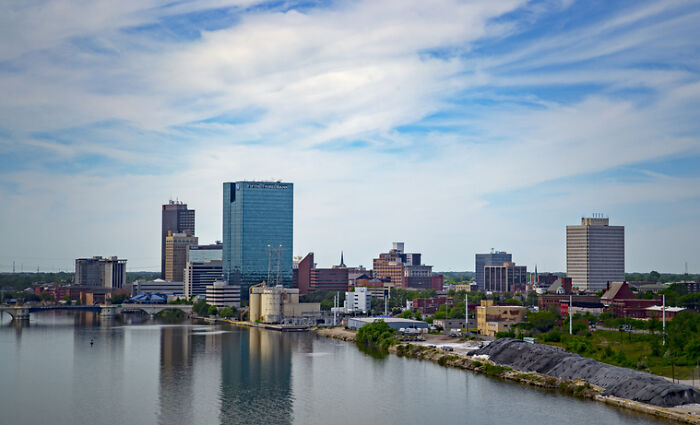 City skyline under a blue sky, illustrating news about woman's unhinged act after breaking into boyfriend&rsquo;s home.