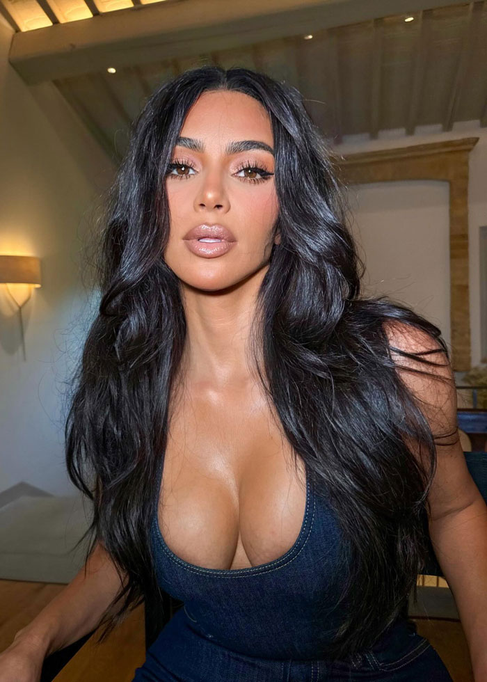 Close-up portrait of a woman with long dark hair and makeup, styled to highlight natural beauty and glamour.