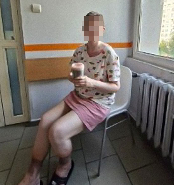 Woman whose parents said she was missing for 27 years sitting in a room, holding a drink, appearing emaciated and weak