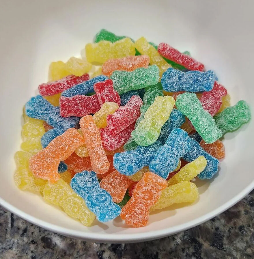 Multicolored sour gummy candies in a white bowl representing popular Halloween candy ranking for 2025 readers vote.