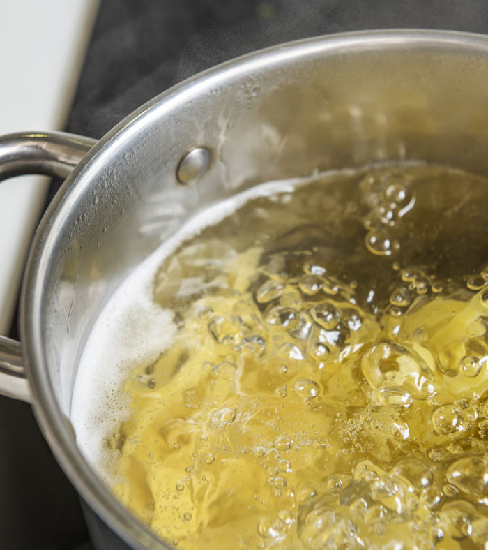 Boiling water in a pot on stove, illustrating tension and urgency related to worst crimes in hometowns.