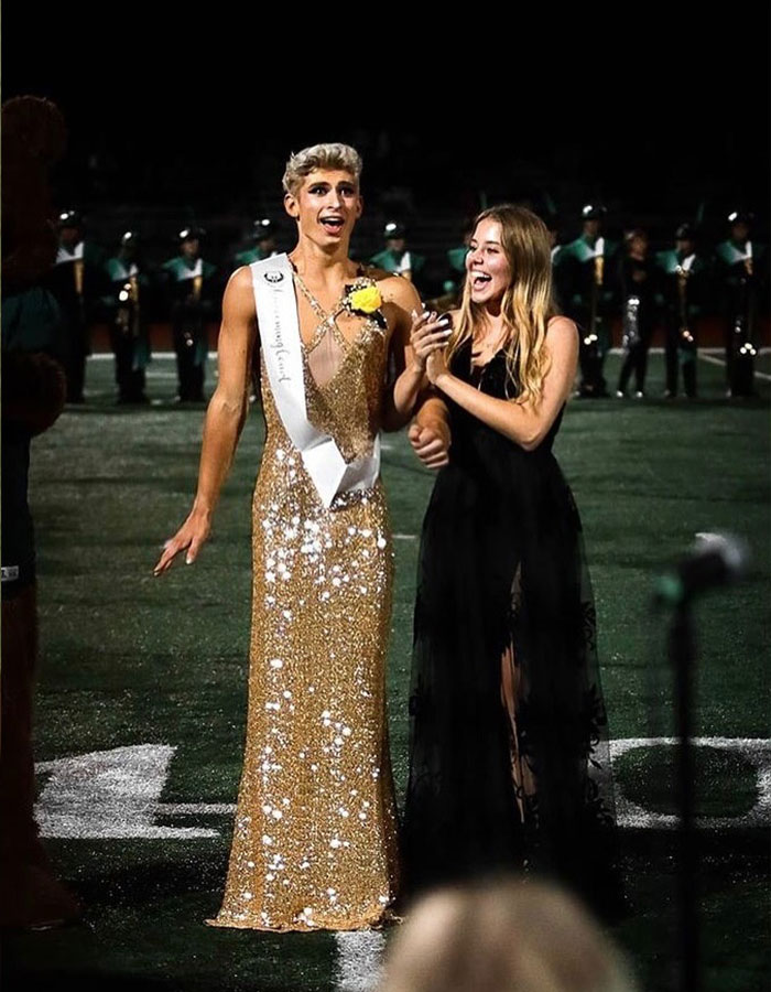 Missouri&rsquo;s first male homecoming queen wearing a gold sequin dress with a sash, celebrating with a smiling female companion.
