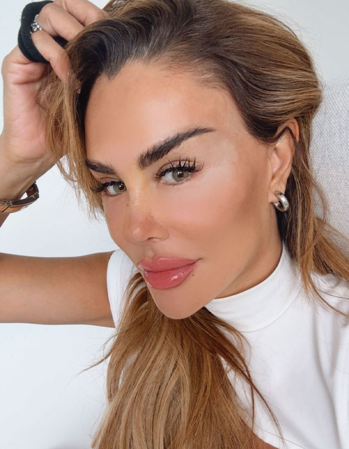 Actress with light brown hair and green eyes posing, highlighting risk of blindness from controversial eye color surgery.