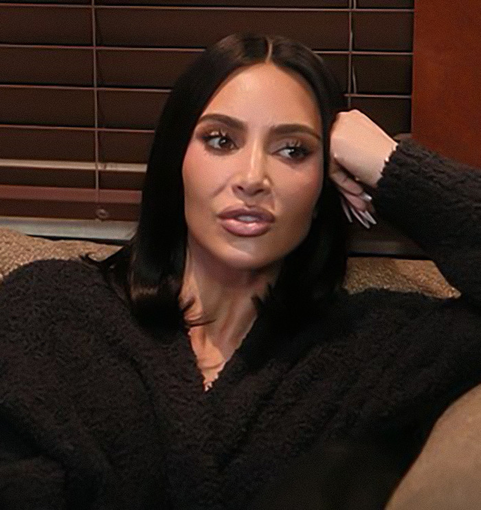 Kim Kardashian sitting on a couch looking thoughtful while discussing the 1969 moon landing conspiracy theory.