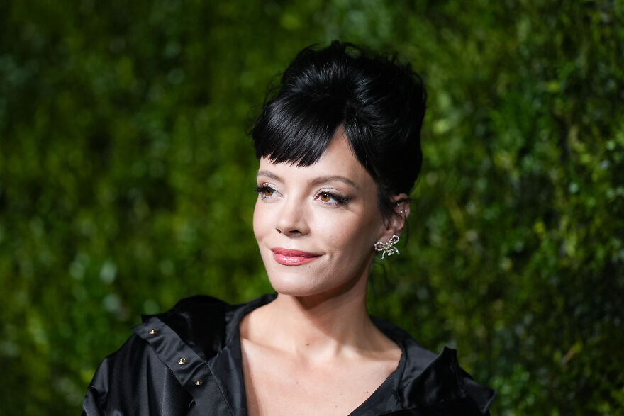 Lily Allen posing outdoors at night with styled black hair and elegant earrings, representing nepo babies in Hollywood’s new generation.