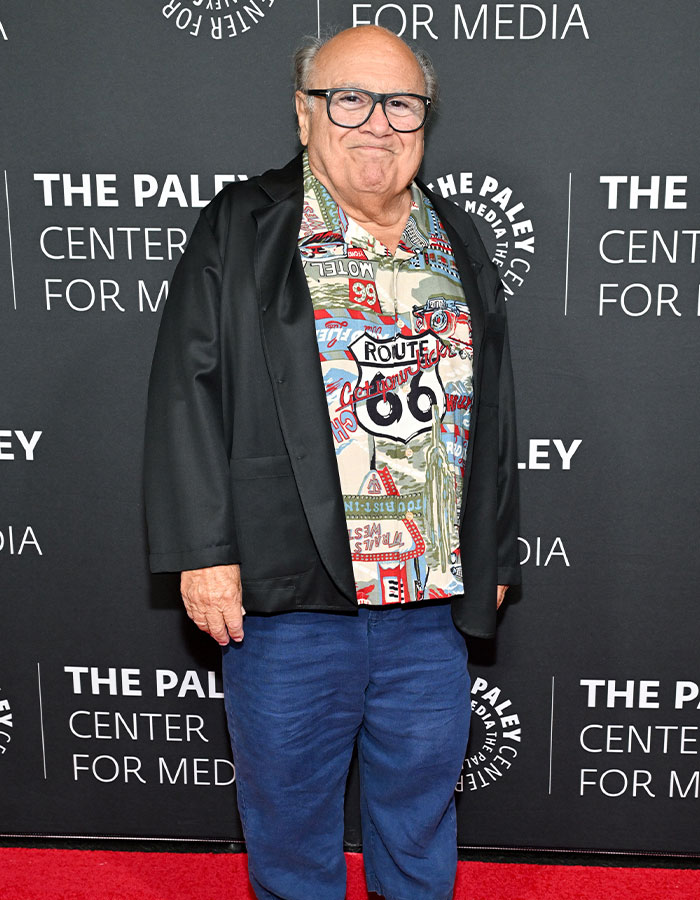 Danny DeVito posing on the red carpet, showcasing one of the famous men who are much shorter than fans imagined.