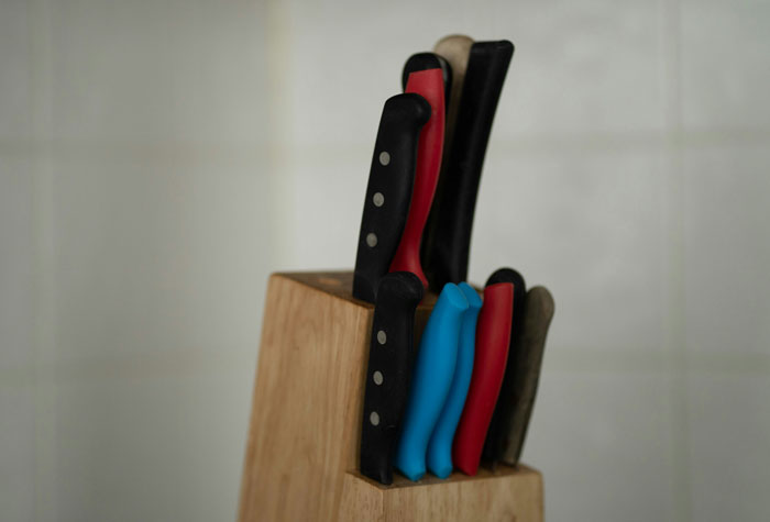 Knife block with various knives in a kitchen, symbolizing discussions about the worst crimes in hometowns.