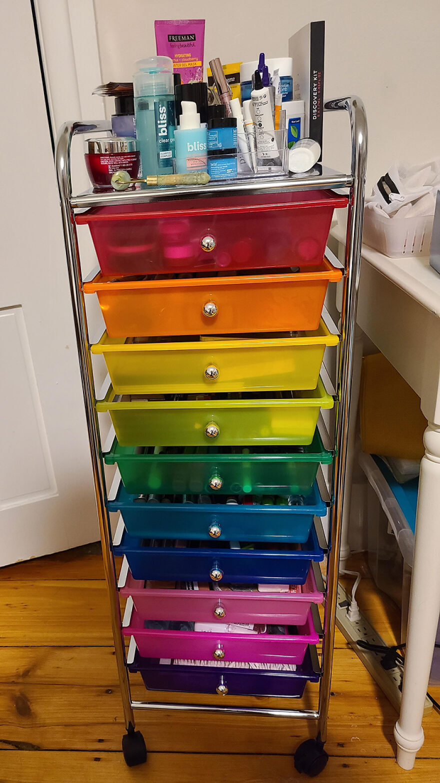 Colorful rolling storage cart with drawers filled with beauty products showcasing organization hacks for home.