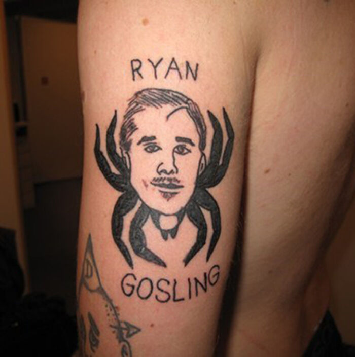 Tattoo of a spider with a man's face and the text Ryan Gosling on a person's upper arm, unusual tattoos on bodies.