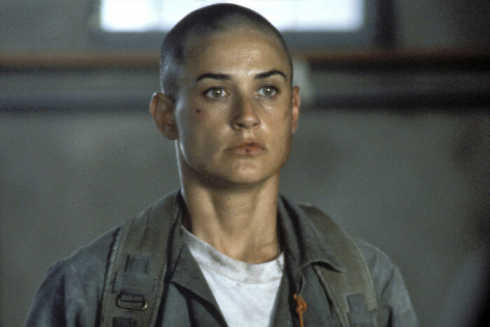 Woman with shaved head in military uniform, representing unrealistic women movie tropes that still annoy audiences.
