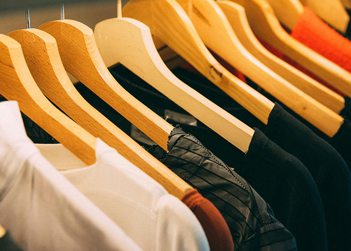 Row of wooden hangers holding various shirts and jackets, illustrating people using loopholes against horrible bosses.