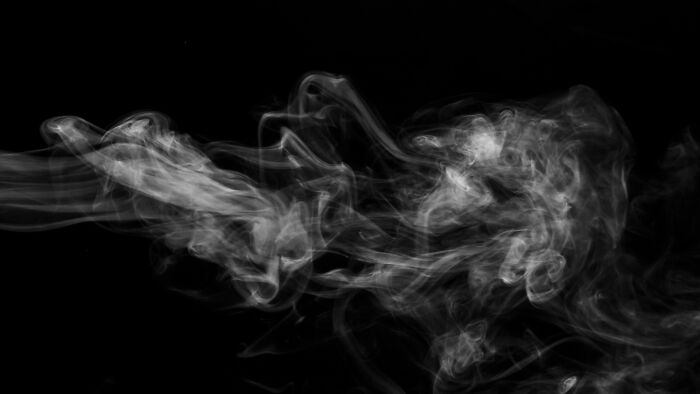 Abstract smoke swirling against a black background illustrating strange and dumb health hacks discussed by patients.
