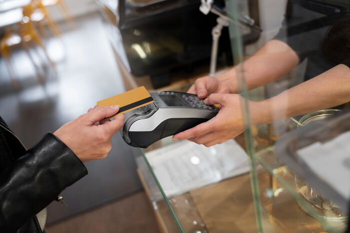 Customer paying with credit card at restaurant counter, illustrating common restaurant staff experiences with bills and payments.