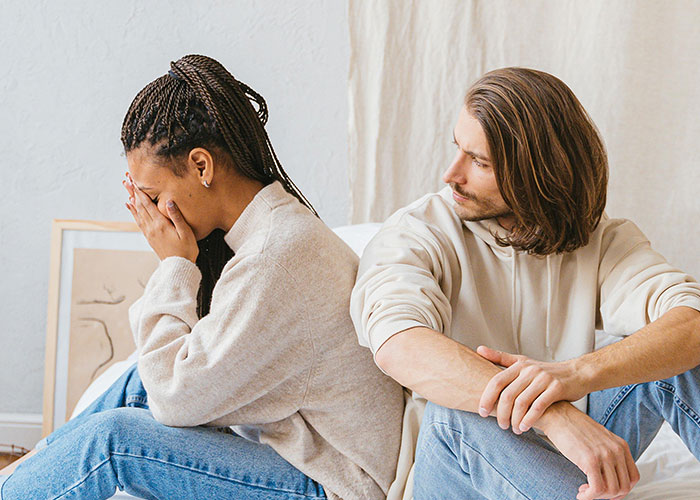 Young woman upset and covering face while a man looks concerned, illustrating mental health myths debunked by psychologists.