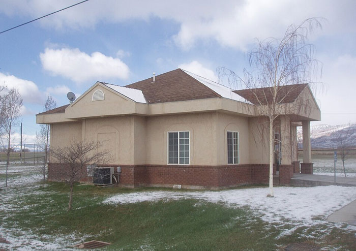 Small beige house by empty snowy field under cloudy sky, an example of worst places visited