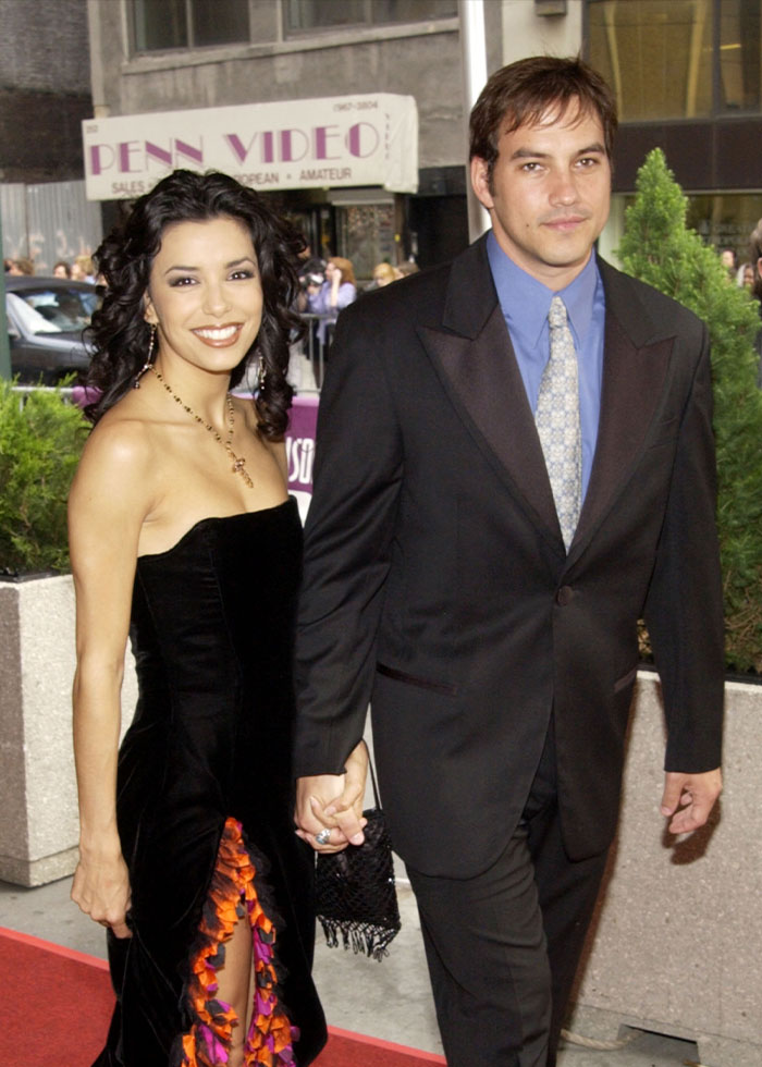 Couple on the red carpet smiling and holding hands, representing forgotten celebrity marriages fans don't remember.