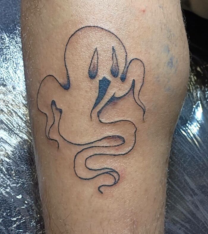Simple black outline ghost tattoo on skin, an unusual and surprising example of tattoos allowed on bodies for life.