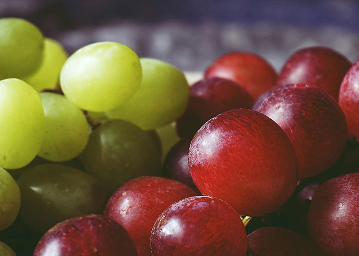 Close-up of green and red grapes with a focus on texture and color, unrelated to zombie or kids topics.