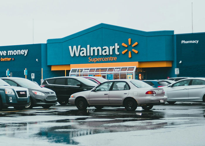 Walmart storefront with cars in the wet parking lot, illustrating people using loopholes against horrible bosses at work.