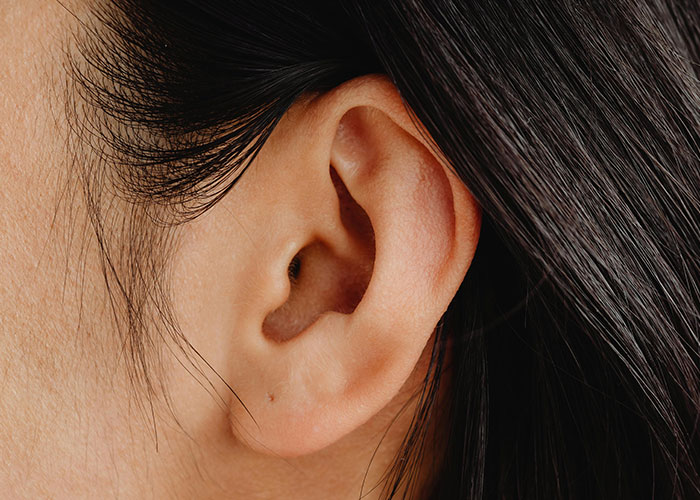 Close-up of a human ear with natural skin texture, illustrating cosmetic procedure outcomes and concerns.