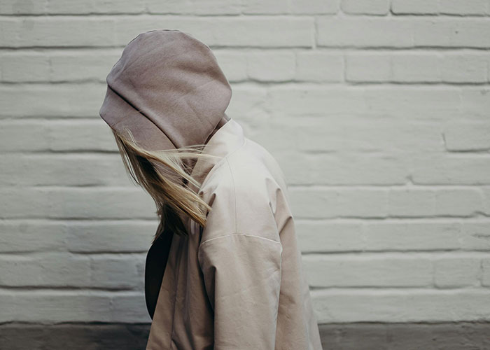 Person wearing a hoodie with hair partially covering face, symbolizing mental health myths and their psychological impact.