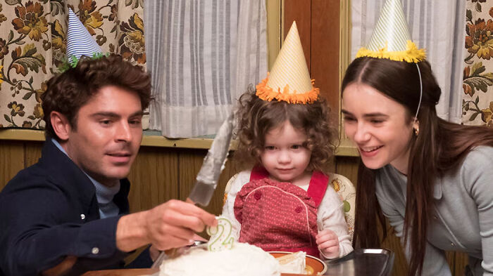 A family wearing party hats celebrating a birthday, featured in movies based on true stories that feel impossible to believe.