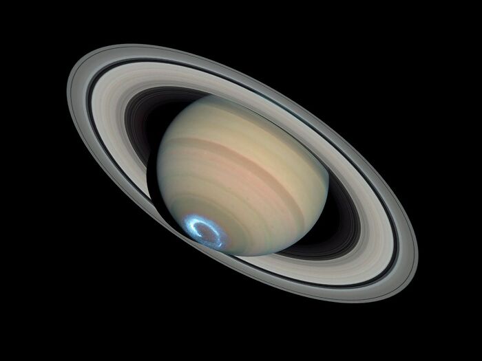 Saturn with detailed rings and glowing south pole aurora, a stunning astronomy photo showing the beauty of space.