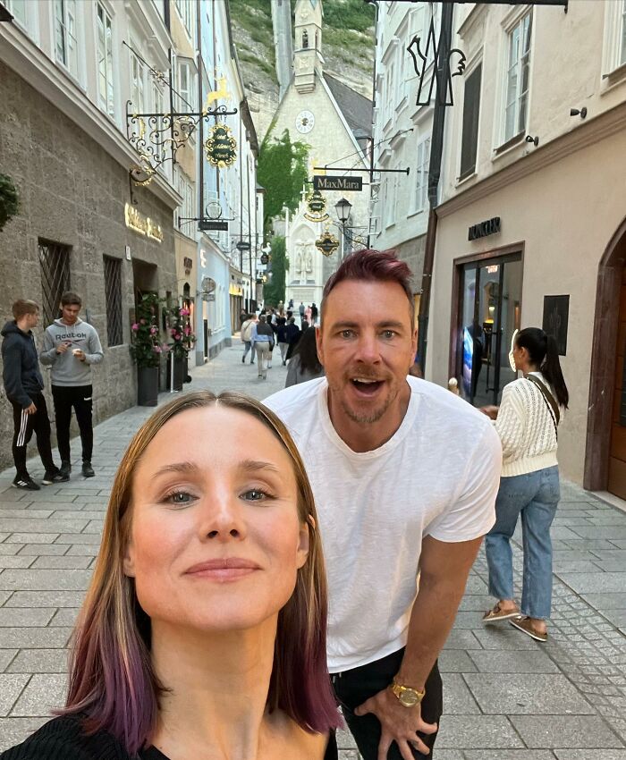 Kristen Bell and a man smiling on a charming street, sparking reactions to Kristen Bell wedding anniversary post.