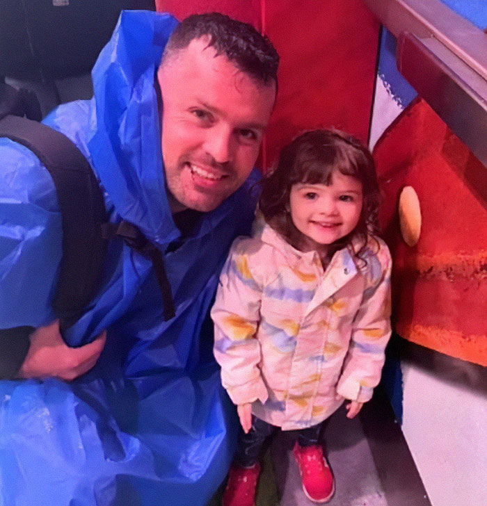 Man smiling next to young girl, highlighting tragic case of dad watched adult videos while 2YO daughter passed away in hot car.