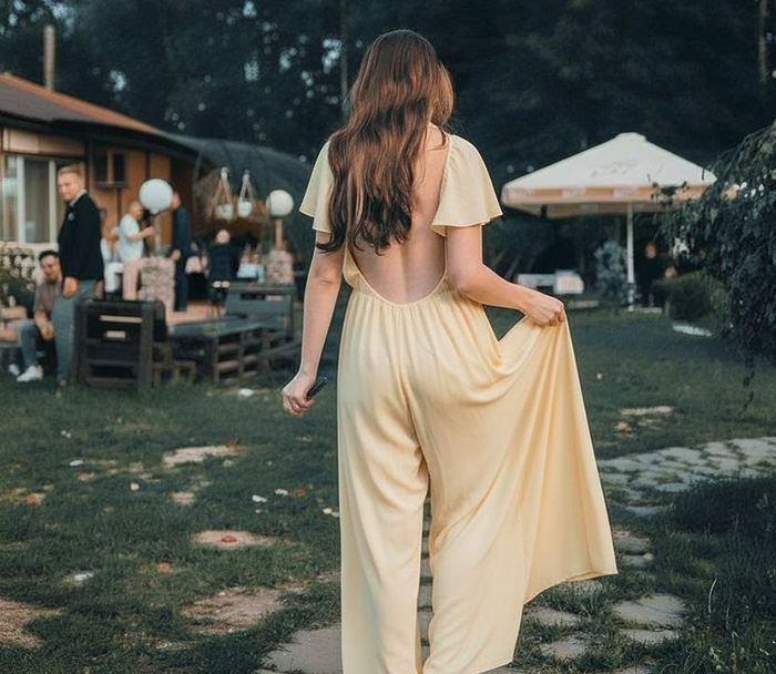 Woman in a backless yellow dress at an outdoor event, highlighting wedding guest attire and confident style response. Woman in a backless yellow dress at an outdoor event, highlighting wedding guest attire and confident style response.