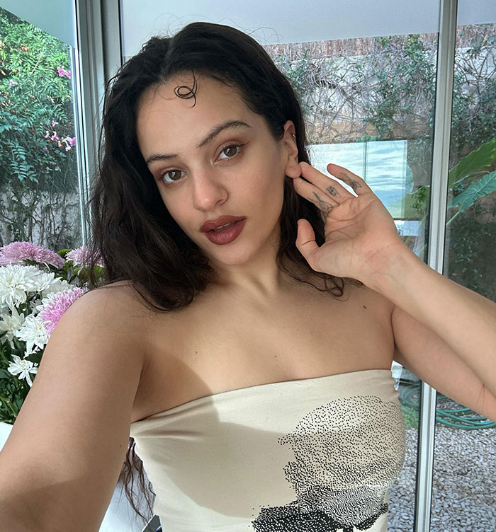 Pop star posing indoors in a strapless top, showing dyed armpit hair, related to Paris Fashion Week reactions.