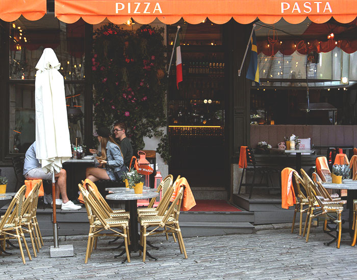 Outdoor Italian restaurant with empty tables and customers dining, related to American tourist request at Olive Garden.