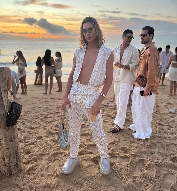 Influencer at beach event wearing stylish outfit, highlighting complications from popular fox eyes surgery concerns.